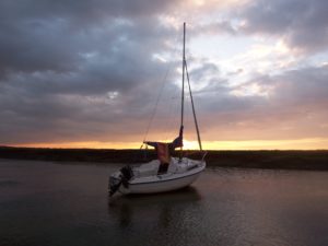 The sun setting over a Seahawk 17 on its mooring at East Quay, Wells-next-the-Sea, North Norfolk